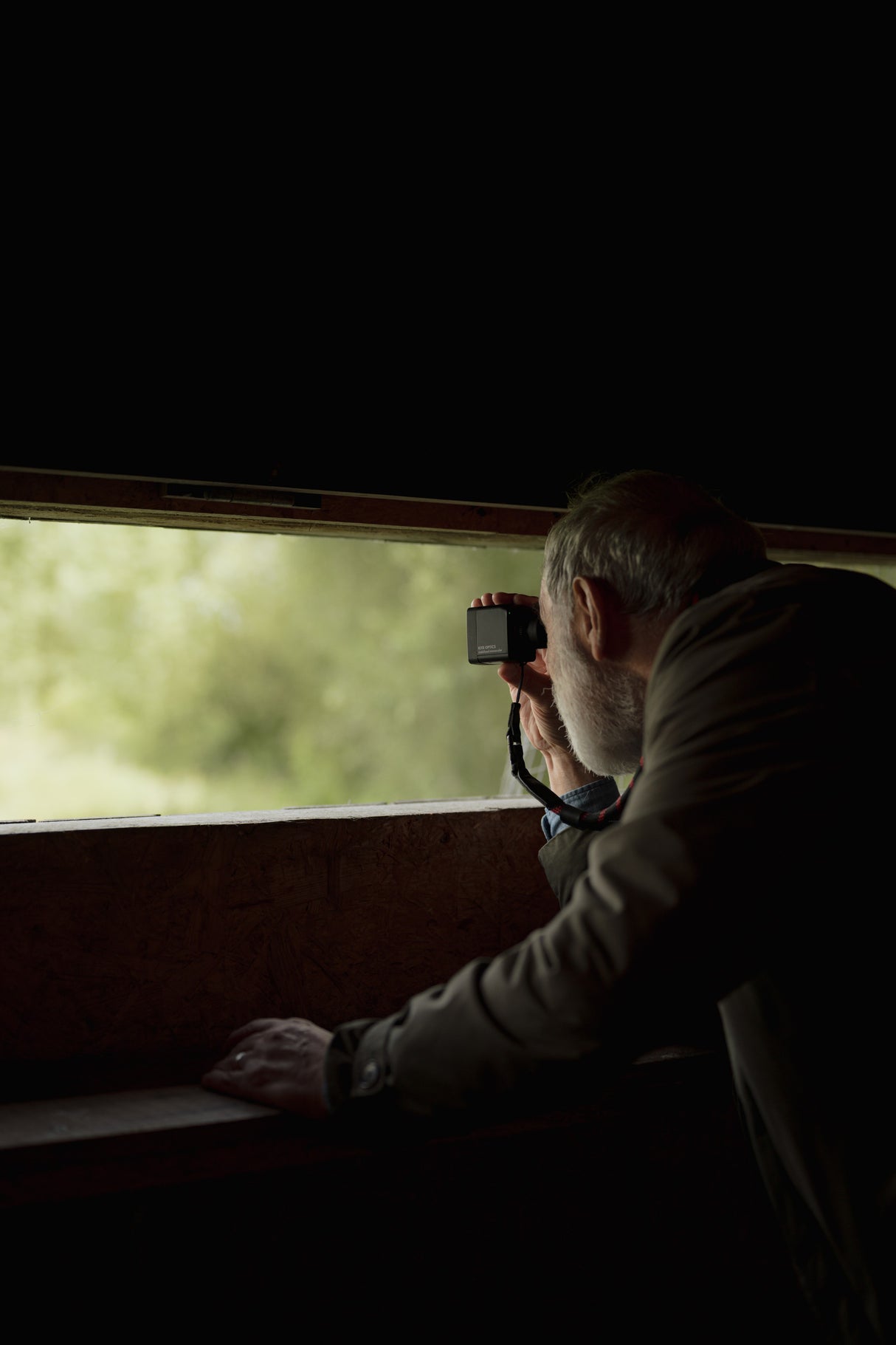Man looking through Kite Stabi One as standalone monocular from inside a bird hide