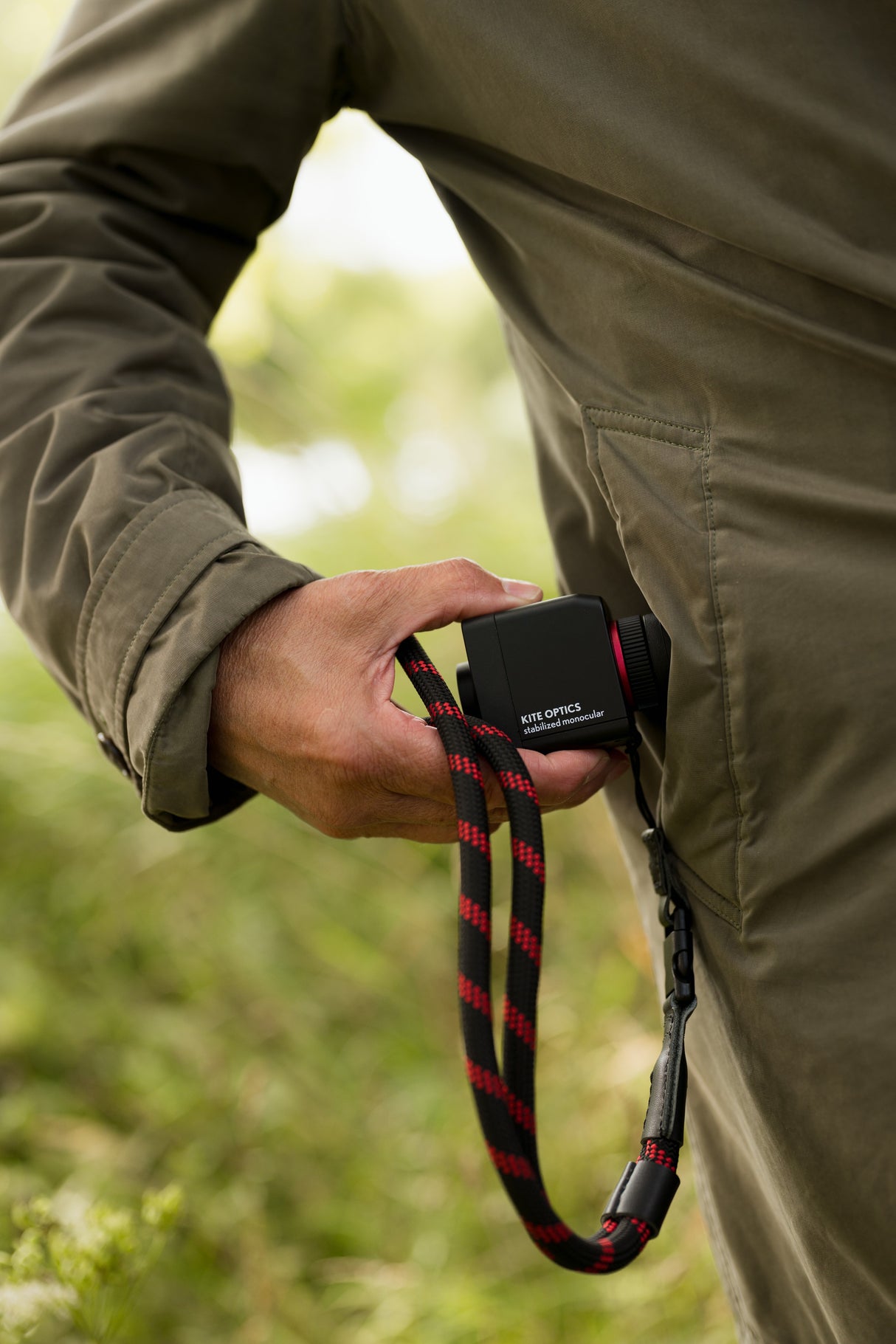 Close-up of Kite Stabi One held at side with neoprene strap, demonstrating pocket-sized design