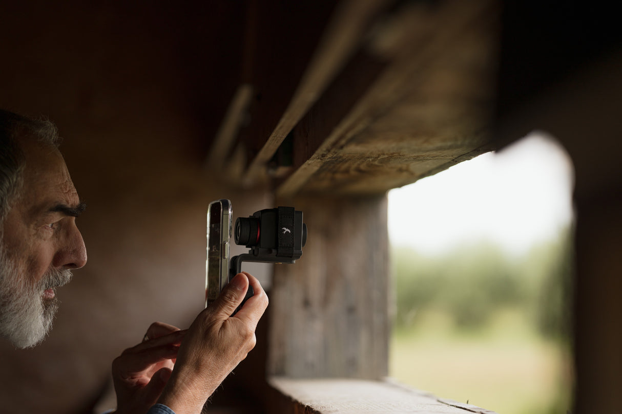 Man using Kite Stabi One with smartphone at bird hide observation window