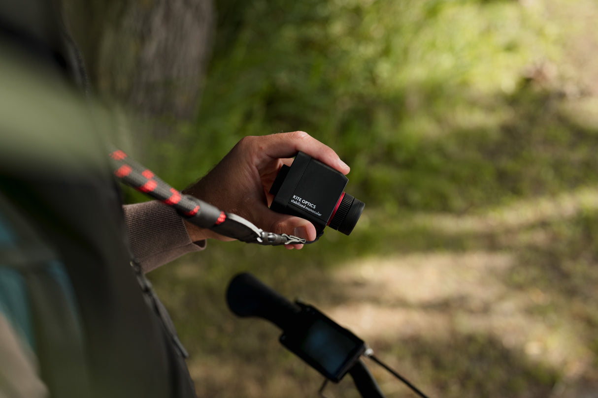 Close-up of cyclist holding Kite Stabi One with neoprene strap near bicycle handlebars