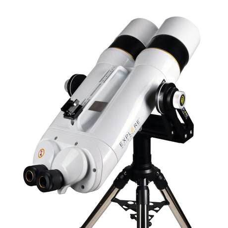 Explore Scientific BT 150mm ED Giant Binocular mounted on a fork mount and stainless steel tripod, angled upward at the sky with both 20mm eyepieces and the altitude friction knob visible