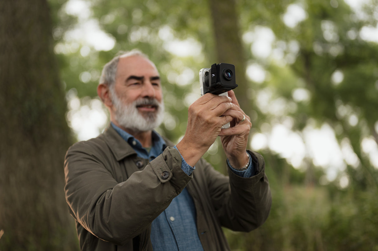 Man digiscoping with Kite Stabi One mounted on smartphone in woodland setting