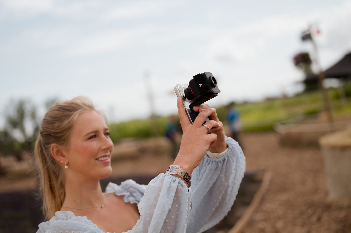 Young woman digiscoping with Kite Stabi One and smartphone at outdoor festival