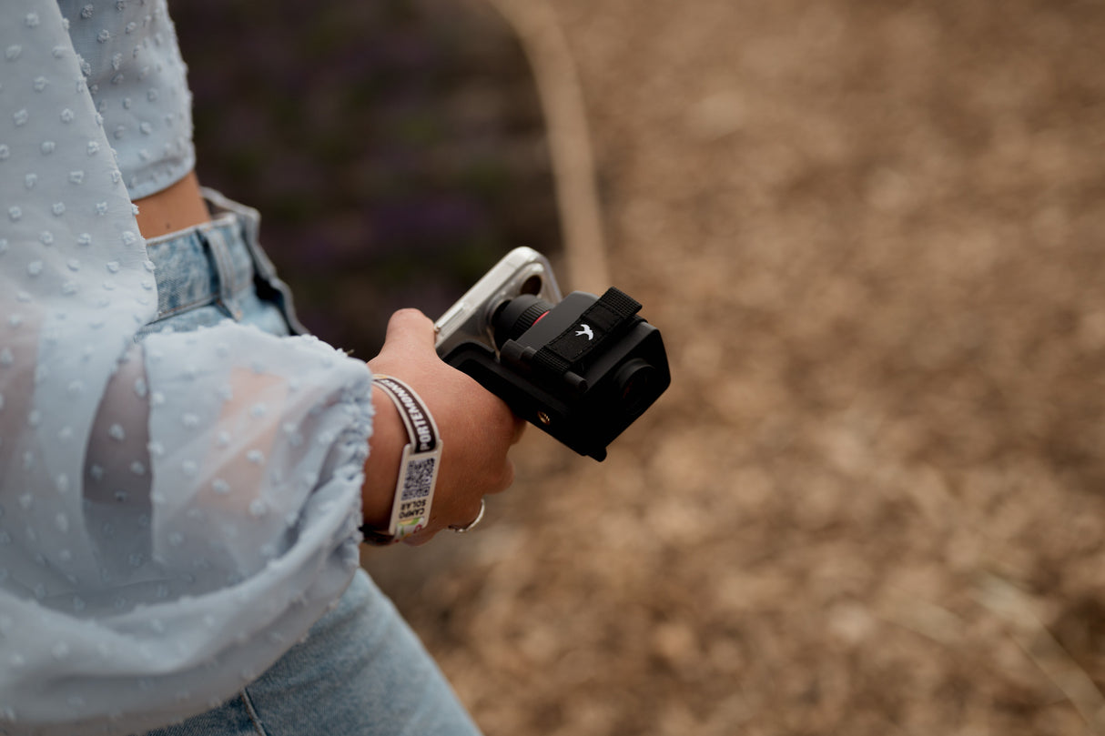 Close-up of woman holding Kite Stabi One with phone mount adapter at outdoor event