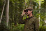 Man in hunting attire looking through Kite Stabi One in forest setting