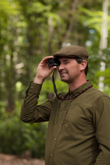 Portrait of hunter looking through Kite Stabi One in woodland with neoprene strap visible