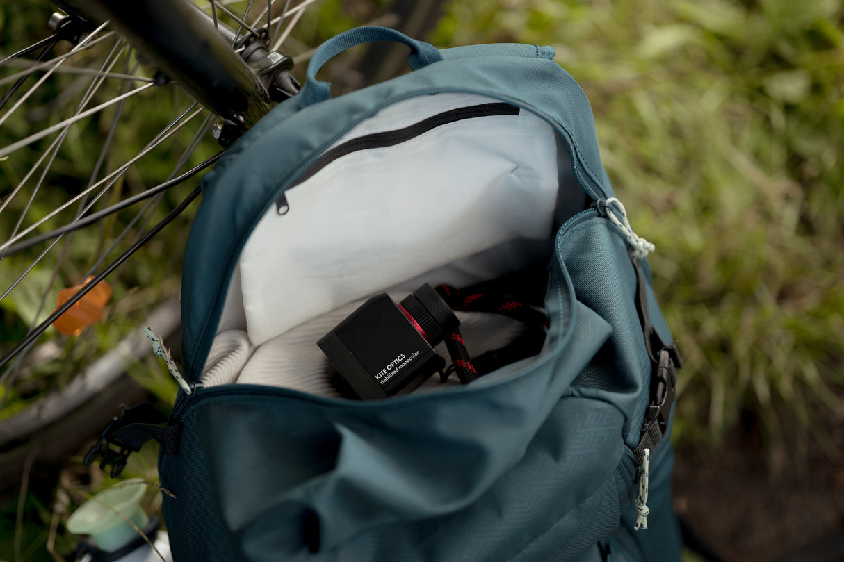 Kite Stabi One tucked in cycling backpack, wider angle showing bicycle and greenery