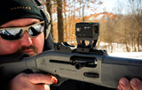 Alpen Argus LT 1x20 enclosed red dot mounted on a pistol slide in an outdoor range setting with the target blurred in the background