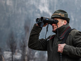 Man using the Guide DN70M 2.0 thermal and 4K digital binocular in a snowy forest