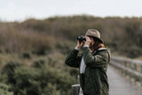 Birder using Kite Optics binoculars on a nature reserve boardwalk